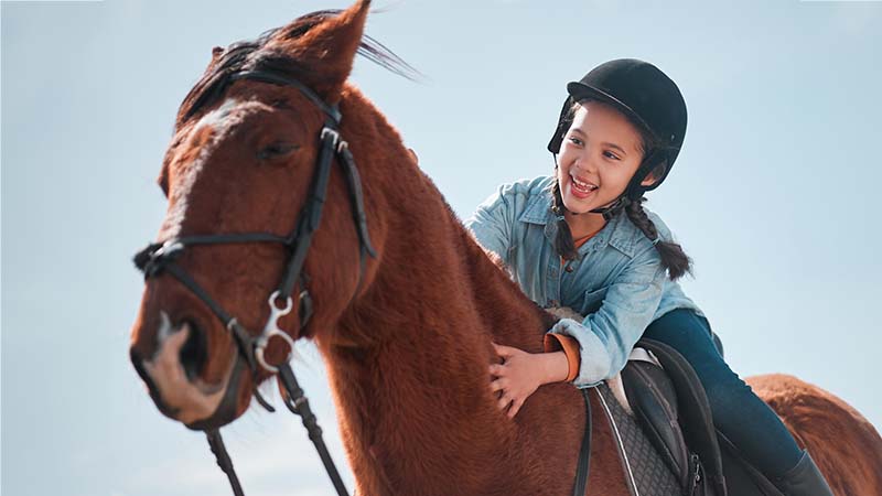 Girl Smiling On A Horse