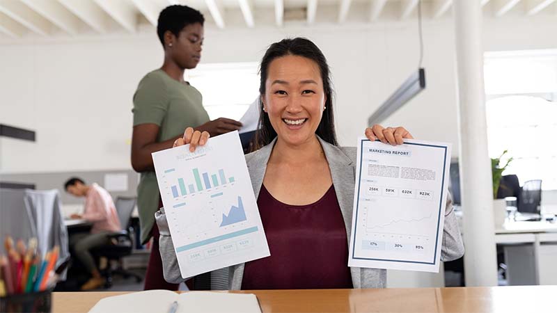 Woman Smiling Holding Graphs
